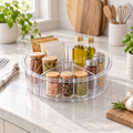 Clear divided Lazy Susan turntable holding spices and oil on a kitchen countertop