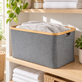 Large dark grey linen basket with bamboo rim on laundry shelving