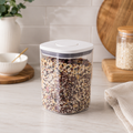 Clear 1000ml push top pantry container with a white lid filled with mixed grains on a kitchen counter