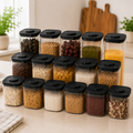 Fifteen clear push top pantry containers with black lids arranged on a kitchen worktop